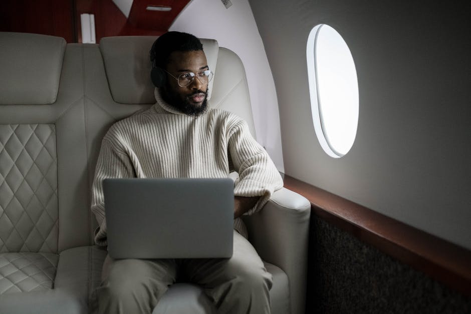 Edgard - Personne assise dans un avion nolisé qui profites des avantages de tranquillité pour travailler.
